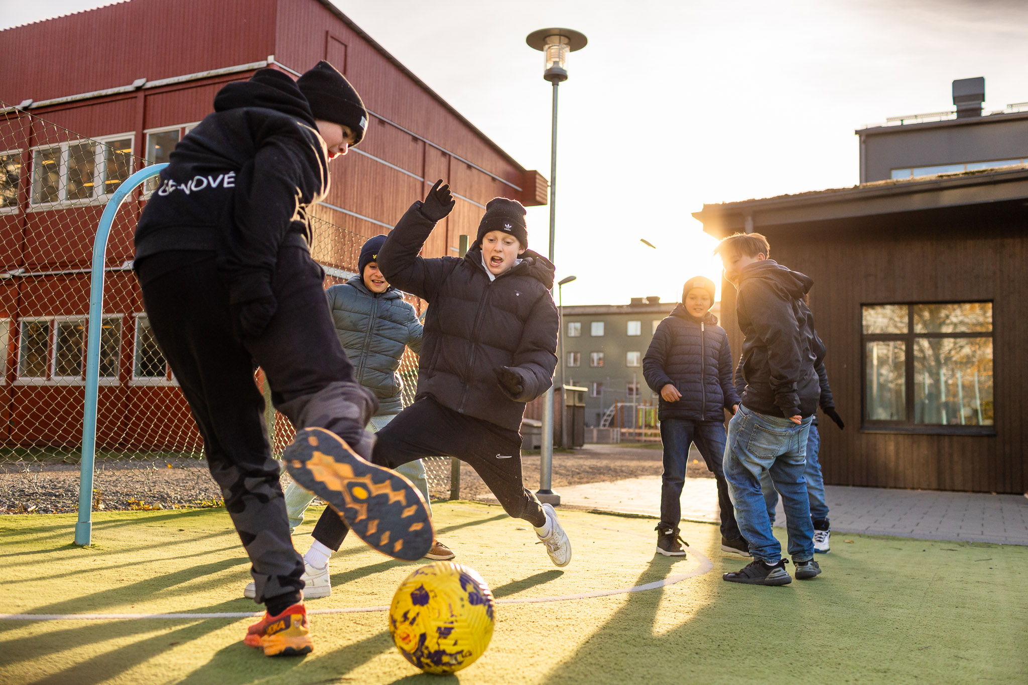 Elever som spelar fotboll på gården