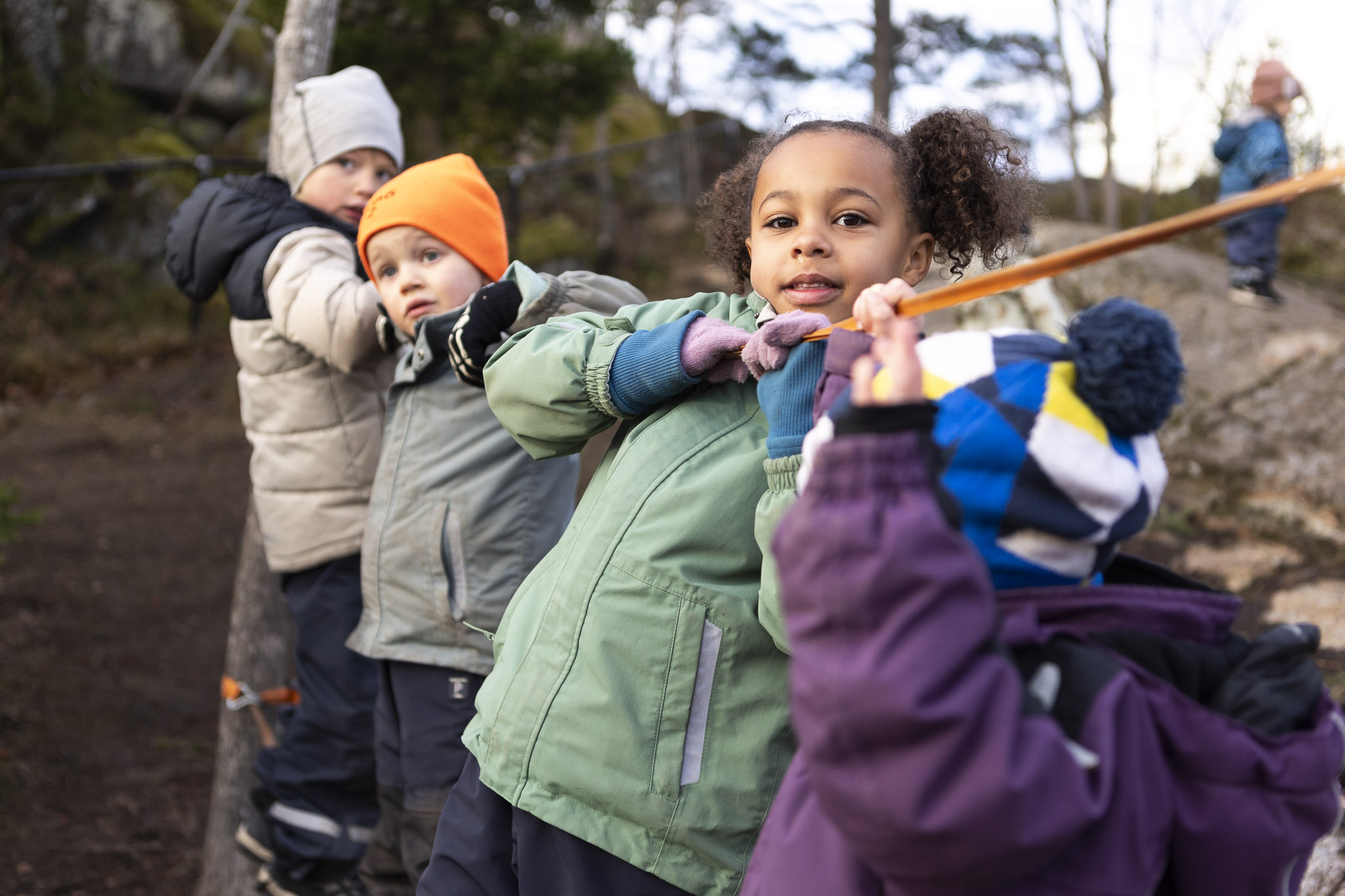 Förskolebarn som klättrar utmed ett rep